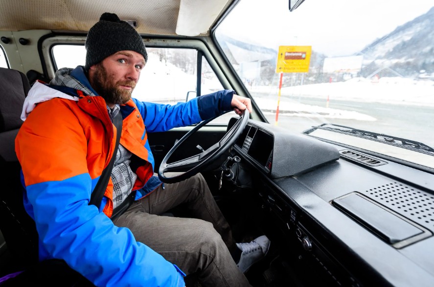 man driving a trailer truck in the snow