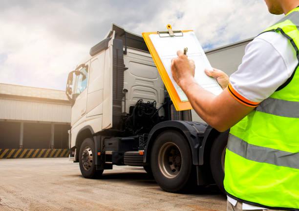 mechanic writing down inspection results on a trailer truck