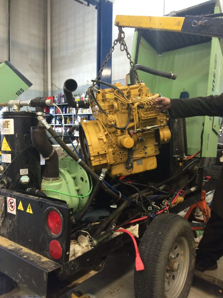 transmission being lifted from a trailer truck for repair